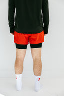 Athlete in red Apex performance running shorts and black Flow hoodie by Nightclubs Suck