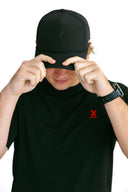 model wearing black performance hat with black X by Nightclubssuck