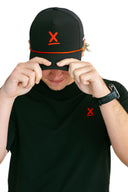 model wearing black performance hat with red X by Nightclubssuck
