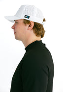 side profile of model wearing white performance hat with blue X by Nightclubssuck