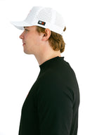 side profile of model wearing white performance hat with red X by Nightclubssuck