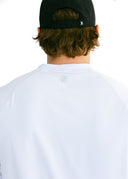 close up of reflective logo on model wearing white performance tee by Nightclubssuck